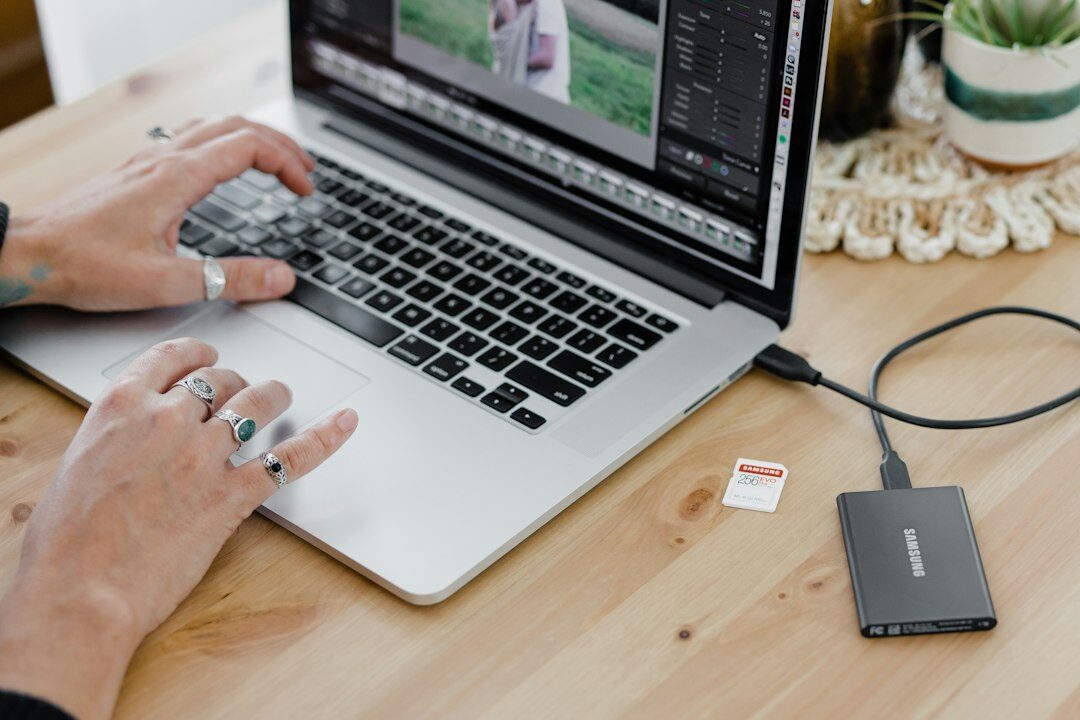 Hands typing on a laptop showing video editing software